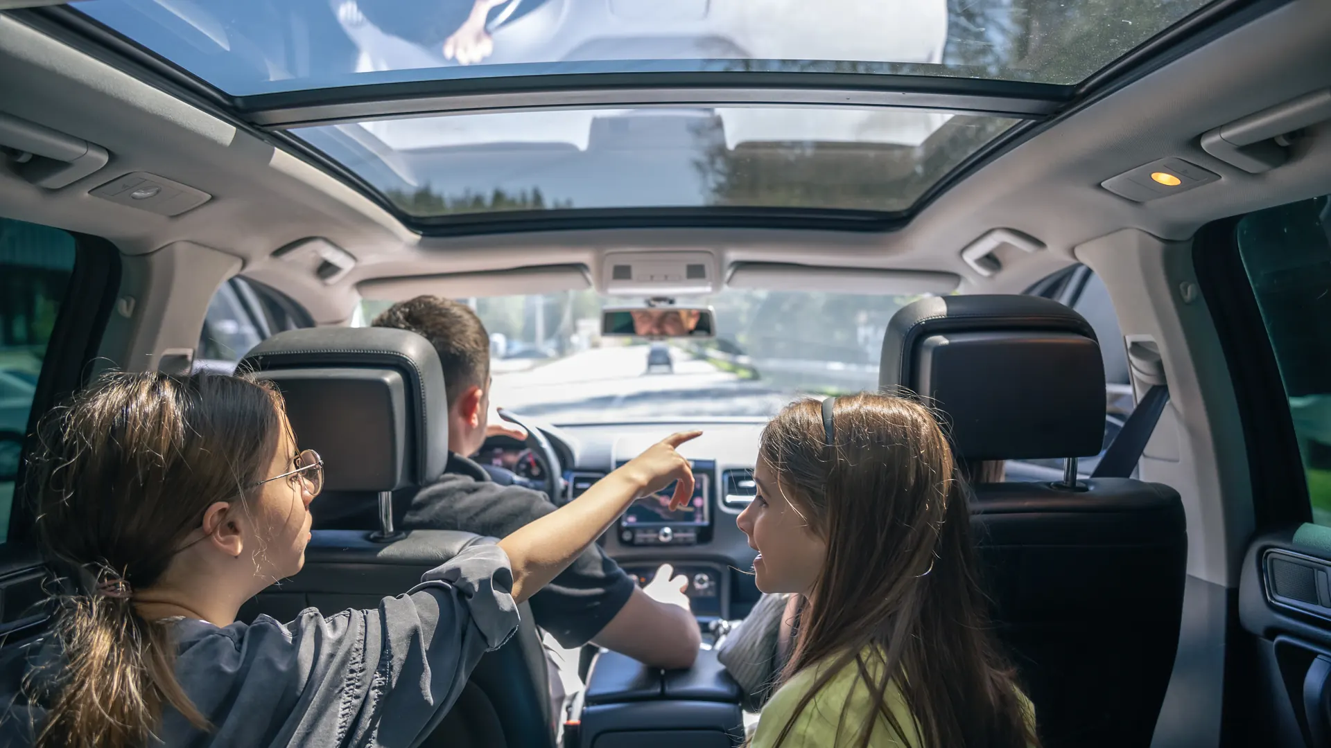 Two young girls buckled safely into the back seat during a family trip